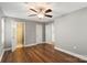 Large bedroom showcasing hardwood floors, a ceiling fan, and access to a bathroom at 113 W 5Th Ave, Gastonia, NC 28052