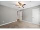 Spacious bedroom with a ceiling fan, carpet floors, and two entry doors at 113 W 5Th Ave, Gastonia, NC 28052