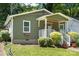 Charming home showcasing a covered porch, neat landscaping, green siding, and a well-kept front yard at 113 W 5Th Ave, Gastonia, NC 28052