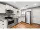 Well-lit kitchen featuring stainless steel appliances, granite countertops, and white cabinets at 113 W 5Th Ave, Gastonia, NC 28052