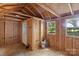 Interior of shed showing paneled walls, bare flooring, a door, windows and overhead beams at 113 W 5Th Ave, Gastonia, NC 28052