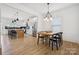 Open dining area with modern lighting, wood floors, and an adjacent kitchen and breakfast bar at 12001 Sam Snead Ct, Lancaster, SC 29720