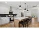 Modern kitchen boasts a spacious island with seating, stainless steel appliances, and stylish black backsplash at 12001 Sam Snead Ct, Lancaster, SC 29720