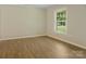 Bright bedroom with wood floors and a large window offering pleasant outdoor views at 1218 Milan Rd, Charlotte, NC 28216