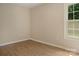 Bedroom featuring neutral walls, light wood-look flooring, and a window offering natural light at 1218 Milan Rd, Charlotte, NC 28216