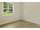 Bright bedroom featuring a large window, neutral walls, and light wood-look flooring at 1218 Milan Rd, Charlotte, NC 28216