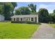 Lovely single-story brick home with a spacious green front yard at 1218 Milan Rd, Charlotte, NC 28216