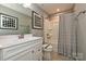 Bathroom with white vanity, large mirror, and tub-shower combo with a stylish striped shower curtain at 124 Kristin View Ln # Townhome A, Troutman, NC 28166