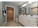 Bathroom features double vanity sinks, white cabinets, a toilet, and a view of a walk-in closet at 124 Kristin View Ln # Townhome A, Troutman, NC 28166