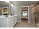 Well-lit bathroom featuring a double vanity, a walk-in shower, and a view of the main bedroom at 124 Kristin View Ln # Townhome A, Troutman, NC 28166