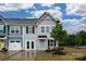 Charming townhome featuring a light blue front door, manicured lawn, and stone accents at 124 Kristin View Ln # Townhome A, Troutman, NC 28166