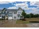 Townhouse exterior showcasing modern design, neat landscaping, and a welcoming blue front door at 124 Kristin View Ln # Townhome A, Troutman, NC 28166