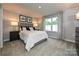 Neutral main bedroom with a large window, plush carpet, bedside lamps, and modern wall decor at 124 Kristin View Ln # Townhome A, Troutman, NC 28166