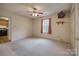Spacious bedroom with neutral carpet, ceiling fan, and window with vibrant red curtains at 130 24Th Nw St, Hickory, NC 28601