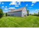 The backyard features a well-manicured lawn and a charming view of the home's architecture under a beautiful blue sky at 138 Chase Water Dr, Mooresville, NC 28117