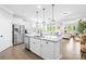 Modern kitchen featuring a granite island, white cabinetry, stainless steel appliances, and hardwood floors at 138 Chase Water Dr, Mooresville, NC 28117