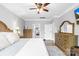 Light-filled main bedroom with wood floors, ceiling fan, and view of the home's luxury bathroom at 138 Chase Water Dr, Mooresville, NC 28117