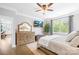 Comfortable main bedroom showcasing hardwood floors, a ceiling fan, television, and large window at 138 Chase Water Dr, Mooresville, NC 28117