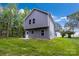 Rear view of a gray, two-story home with a back door, small patio, and grassy yard at 1420 Tyler St, Kannapolis, NC 28083
