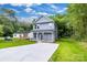 Charming two-story home with gray siding, a covered porch, and a long concrete driveway on a beautiful, sunny day at 1420 Tyler St, Kannapolis, NC 28083