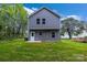 Rear view of a gray, two-story home with a back door, small patio and grassy yard at 1420 Tyler St, Kannapolis, NC 28083