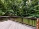 View from the wooden deck overlooking the backyard with its lush greenery and mature trees at 1423 Piper Ct, Concord, NC 28025