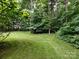 Lush green backyard with a border of dense trees, offering a serene and private outdoor space at 1423 Piper Ct, Concord, NC 28025
