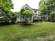 Spacious backyard featuring a well-maintained lawn, mature trees, and a wooden deck, creating a private outdoor oasis at 1423 Piper Ct, Concord, NC 28025