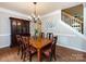 Classic dining room featuring a hardwood table, china cabinet, and staircase view at 1423 Piper Ct, Concord, NC 28025