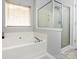 Modern bathtub and glass-enclosed shower create a spa-like atmosphere in the bathroom at 1423 Piper Ct, Concord, NC 28025