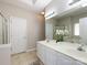 Bright bathroom with dual sinks, white cabinets, a large mirror, and decorative orchids at 1423 Piper Ct, Concord, NC 28025
