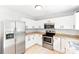 Bright kitchen features stainless steel appliances, white cabinetry and granite countertops at 1515 Kingdom Way, Fort Mill, SC 29707