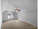 This carpeted bedroom includes a ceiling fan and bright window overlooking the neighborhood at 1523 Merrie Meadow Ct, Rock Hill, SC 29732