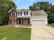Charming two-story home featuring a brick and vinyl facade, attached two car garage, and a well-maintained lawn at 1523 Merrie Meadow Ct, Rock Hill, SC 29732
