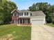 Charming two-story home featuring a brick and vinyl facade, attached two car garage, and a well-maintained lawn at 1523 Merrie Meadow Ct, Rock Hill, SC 29732