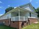 Covered back porch with white railing, brick foundation and ceiling fan at 1700 Pickwick Ave, Kannapolis, NC 28083