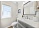 Well-lit bathroom with vanity, gray cabinetry, modern fixtures, and a window at 18522 Victoria Bay Dr, Cornelius, NC 28031