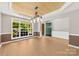 Sunlit dining room with wood-look ceiling, modern light fixture, and large window at 18522 Victoria Bay Dr, Cornelius, NC 28031