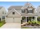 Charming two-story home featuring a stone facade, two-car garage, and welcoming front porch at 18522 Victoria Bay Dr, Cornelius, NC 28031