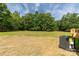 Large grassy backyard with mature trees and an air conditioning unit at 2007 Sugar Hill Rd, York, SC 29745