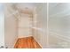 Walk-in closet featuring hardwood floors, shelving, and a door at the entry at 203 Ewing Dr, Belmont, NC 28012