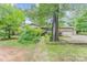 Traditional tan brick home with mature landscaping, grassy yard, and long concrete driveway at 203 Ewing Dr, Belmont, NC 28012