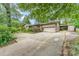 Traditional tan brick home featuring an attached two-car garage and long concrete driveway at 203 Ewing Dr, Belmont, NC 28012