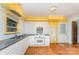Galley kitchen with white appliances, laminate countertops, and adjacent dining area with hardwood floors at 203 Ewing Dr, Belmont, NC 28012
