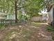 Backyard featuring mature shade trees, playset, shed, and partial fencing at 214 Tenth St, Cramerton, NC 28032