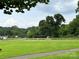Baseball field with a covered dugout, chain-link fencing and green grass at 214 Tenth St, Cramerton, NC 28032