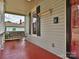 Inviting front porch features a swing, red painted floor, neutral siding, and black shutters at 214 Tenth St, Cramerton, NC 28032