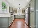 Spacious kitchen with stainless appliances, sage green cabinets, hardwood floors, and lots of natural light at 214 Tenth St, Cramerton, NC 28032