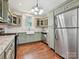 Updated kitchen with stainless steel appliances, sage green cabinets, hardwood floors, and bright lighting at 214 Tenth St, Cramerton, NC 28032