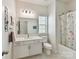 Bright bathroom with white vanity, large mirror, and shower with floral curtain at 2343 Mt. Harmony Church Rd, Matthews, NC 28104